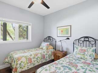 This charming bedroom features two twin beds with decorative headboards, perfect for guests or children.