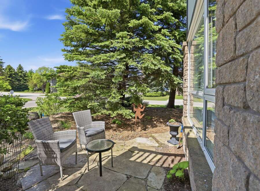 Enjoy your morning coffee on this charming stone patio, complete with comfortable wicker seating and a glass-top table.