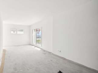 This bright and airy unfinished room features a clean slate with white walls and a concrete floor, ready for your personal touch.