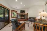 Cozy up by the stone fireplace in this inviting living room, perfect for relaxing after a day of outdoor adventures.