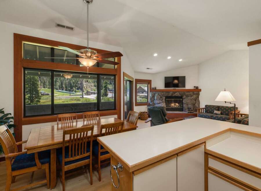 Enjoy breathtaking mountain views from this spacious dining area, featuring a large wooden table and chairs perfect for family gatherings.