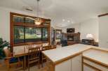 Enjoy breathtaking mountain views from this spacious dining area, featuring a large wooden table and chairs perfect for family gatherings.
