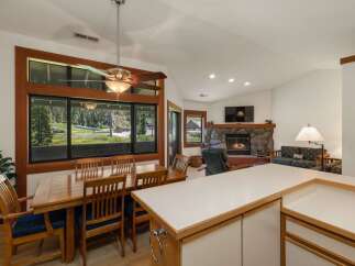 Enjoy breathtaking mountain views from this spacious dining area, featuring a large wooden table and chairs perfect for family gatherings.