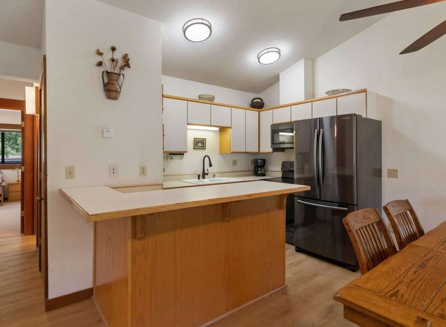 Discover this charming kitchen featuring ample white cabinetry and a sleek stainless steel refrigerator.