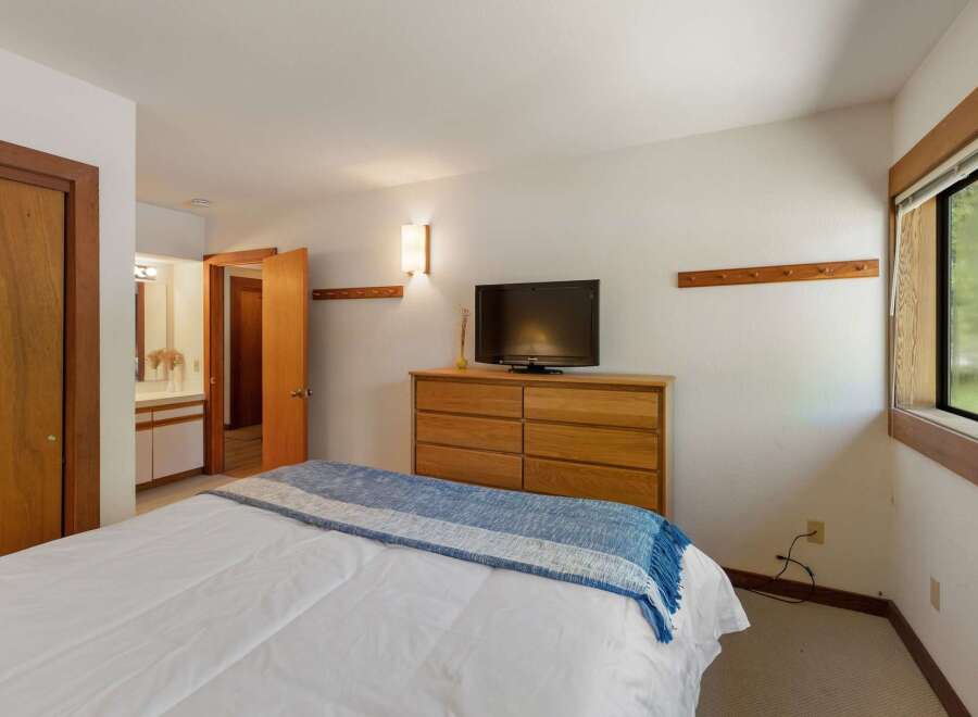 This inviting bedroom features a comfortable bed adorned with a blue and white throw blanket, perfect for cozy nights.