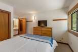 This inviting bedroom features a comfortable bed adorned with a blue and white throw blanket, perfect for cozy nights.
