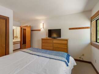 This inviting bedroom features a comfortable bed adorned with a blue and white throw blanket, perfect for cozy nights.