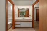 This bathroom features a spacious vanity with ample counter space and storage, perfect for organizing your essentials.