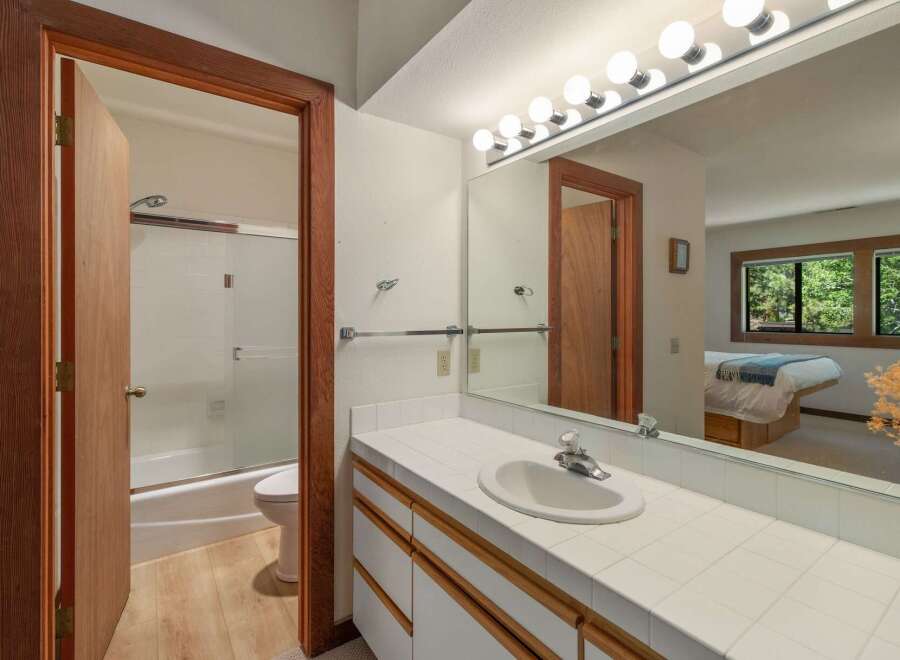 This bathroom features a spacious vanity with a tiled countertop and ample storage, perfect for organizing your essentials.