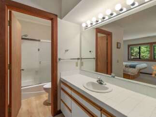 This bathroom features a spacious vanity with a tiled countertop and ample storage, perfect for organizing your essentials.