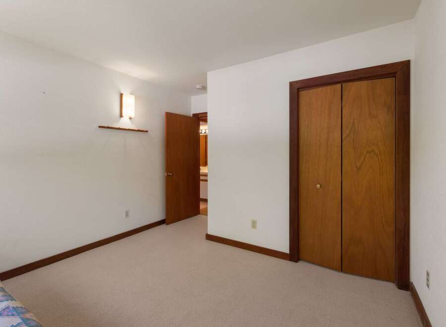This bedroom features a neutral carpet and white walls, creating a bright and airy atmosphere.