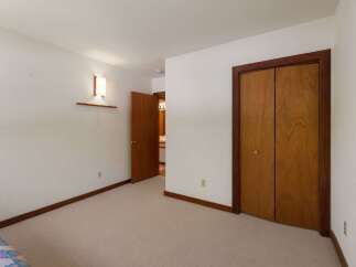 This bedroom features a neutral carpet and white walls, creating a bright and airy atmosphere.