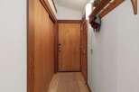 Step into this charming entryway featuring warm wooden doors and a convenient coat rack with shelving.