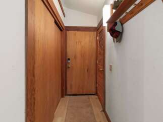 Step into this charming entryway featuring warm wooden doors and a convenient coat rack with shelving.