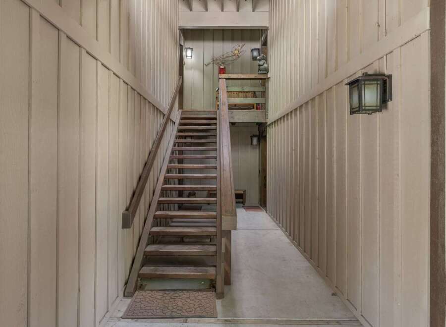 Ascend to new heights in this charming property featuring a rustic wooden staircase leading to the upper levels.