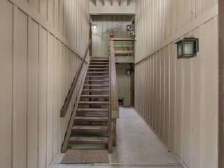 Ascend to new heights in this charming property featuring a rustic wooden staircase leading to the upper levels.