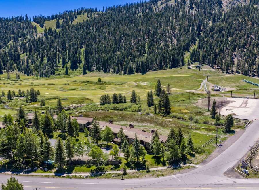 Discover this stunning property nestled amidst a lush forest, offering breathtaking mountain views and a serene golf course setting.