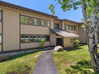 Discover this charming property featuring a welcoming entryway with a covered porch and a large boulder accent.
