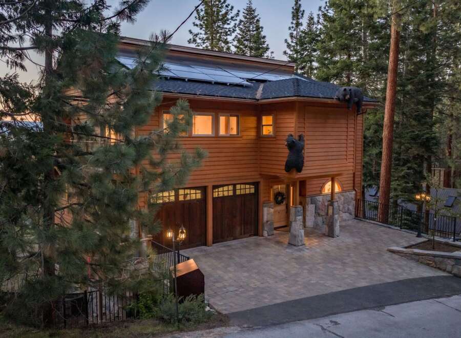 Experience the unique charm of this mountain retreat, featuring a striking wooden exterior and playful bear decorations.