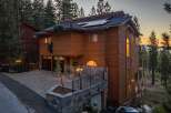 Experience luxury mountain living in this stunning wood-sided home, featuring a unique bear-themed exterior decoration.