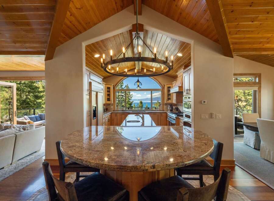 Experience breathtaking lake and mountain views from this stunning kitchen, featuring a large granite island and ample custom cabinetry.