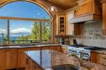 Experience breathtaking lake and mountain views from this stunning kitchen, featuring a large arched window that floods the space with natural light.