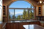Experience breathtaking lake and mountain views from this stunning kitchen, featuring a large arched window that floods the space with natural light.