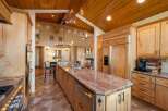 Experience luxury living in this stunning kitchen, featuring custom wood cabinetry and a large granite island with a built-in sink.