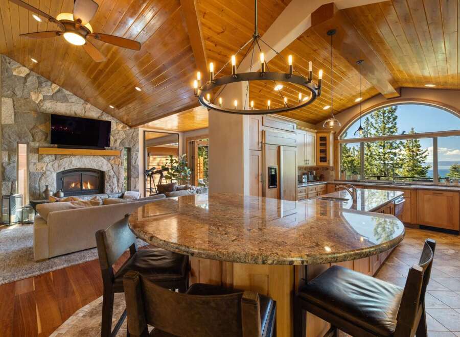 Experience luxury living in this stunning open-concept home, featuring a grand stone fireplace and a spacious kitchen with a large granite island perfect for entertaining.