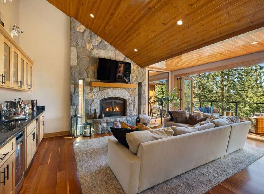 Experience luxury living in this stunning mountain retreat, featuring a grand stone fireplace and a beautifully appointed wet bar perfect for entertaining.