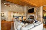 Experience rustic luxury in this stunning living room, featuring a grand stone fireplace and a fully equipped wet bar perfect for entertaining.