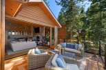 Experience seamless indoor-outdoor living with this stunning property, featuring a spacious deck perfect for entertaining and a cozy interior with a stone fireplace and a well-appointed bar area.