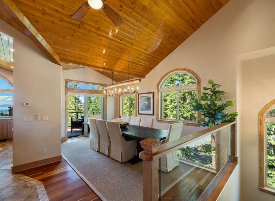 Experience breathtaking views from this stunning dining room, featuring a large wooden table with upholstered chairs, perfect for hosting memorable meals.