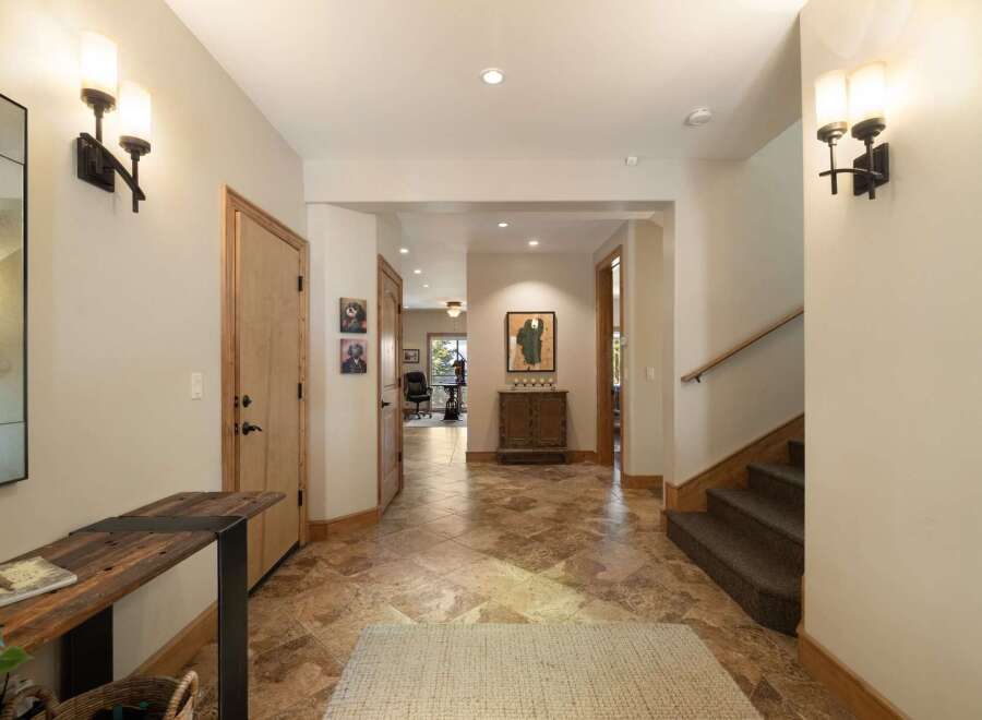 Step into this welcoming entryway featuring a rustic wooden console table and a large decorative mirror, perfect for a stylish greeting.