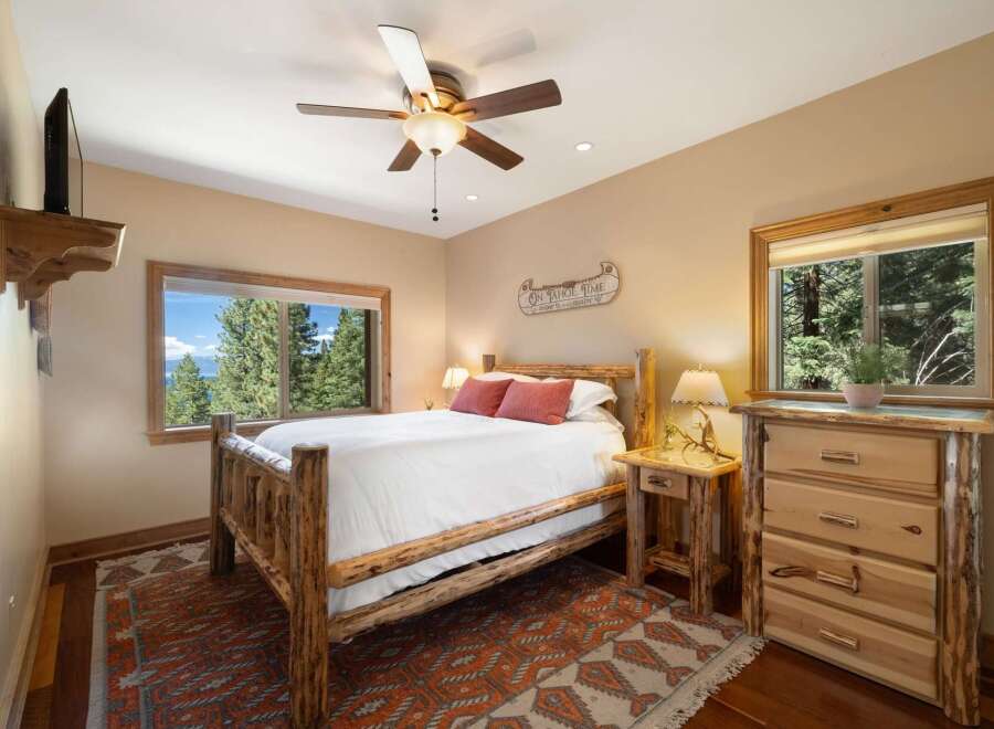 Experience rustic charm in this cozy bedroom, featuring a handcrafted log bed and a stunning mountain view from the window.