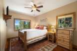 Experience rustic charm in this cozy bedroom, featuring a handcrafted log bed and a stunning mountain view from the window.