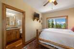 Experience breathtaking lake and mountain views from this charming bedroom, complete with a rustic log bed and a private ensuite bathroom.