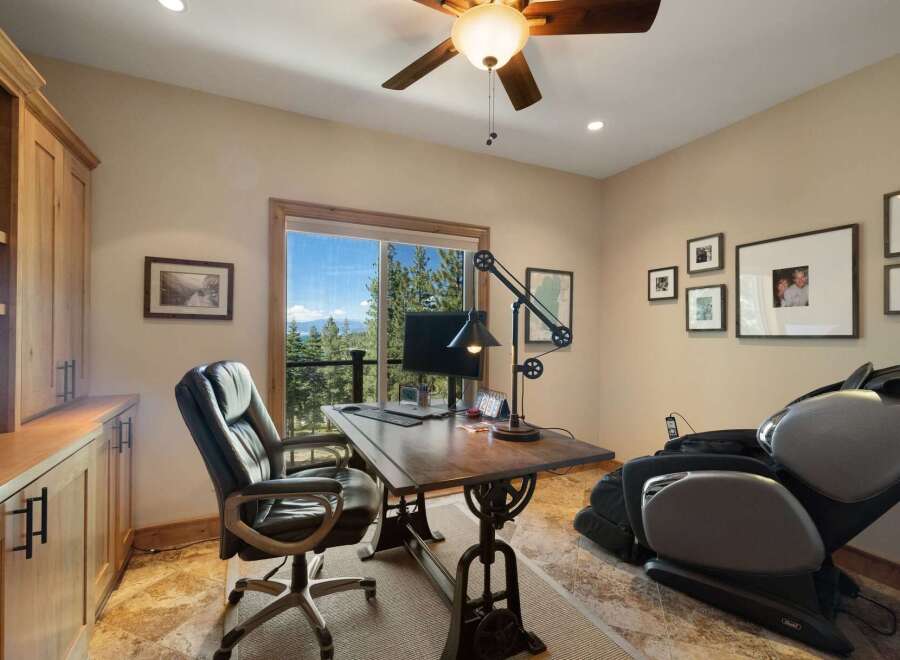 This home office offers a stunning view of the surrounding landscape through a large window, perfect for inspiration while you work.