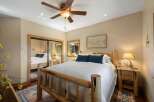 Experience rustic charm in this inviting bedroom, featuring a cozy log bed and plush blue accent pillows.
