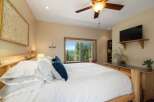 Experience breathtaking mountain views from this serene bedroom, featuring a comfortable king-size bed and a large window overlooking a lush forest.