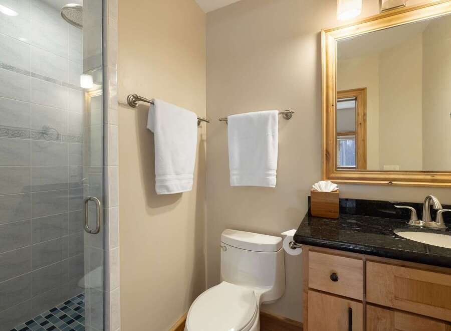 This modern bathroom features a sleek glass-enclosed shower with stylish tile work and a rainfall showerhead.