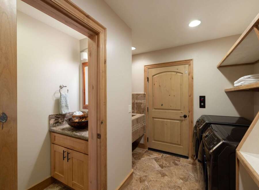 This spacious laundry room features a convenient half-bathroom, perfect for quick cleanups.