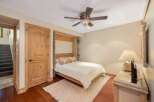 This charming bedroom features a comfortable queen-size bed with a white duvet, complemented by decorative pillows.