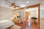 Experience ultimate relaxation in this serene bedroom featuring a comfortable bed and a dedicated massage area.