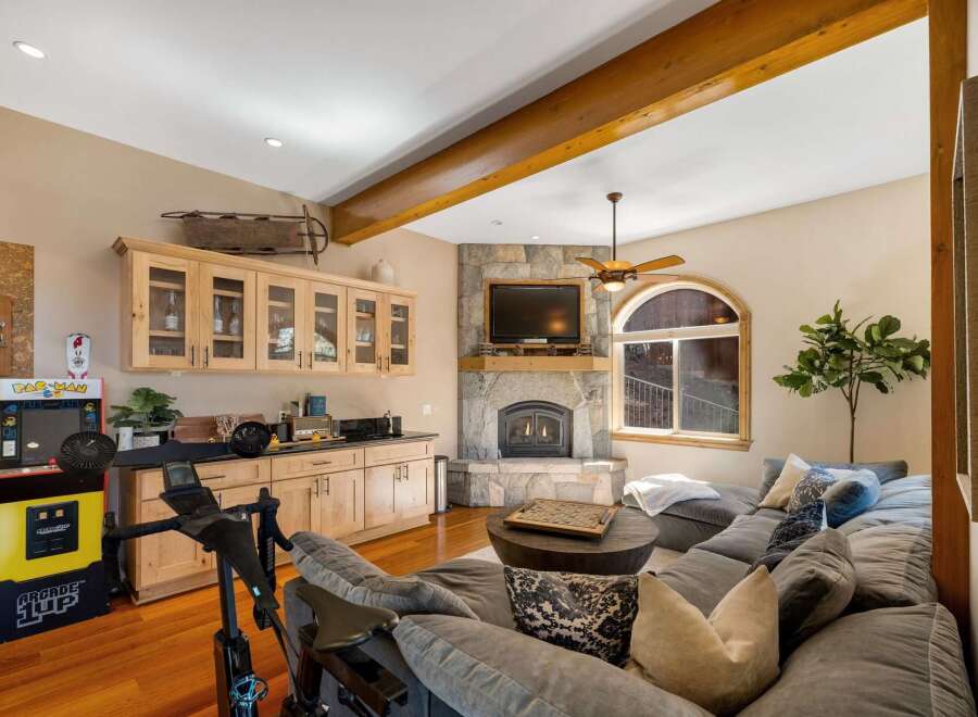 Experience ultimate relaxation and entertainment in this stunning living space, featuring a cozy stone fireplace and a large, comfortable sectional sofa perfect for gatherings.