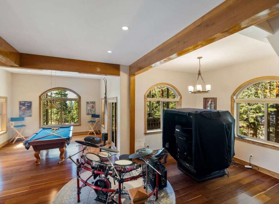 Experience ultimate entertainment in this spacious game room, featuring a professional pool table and a complete drum set for endless fun.