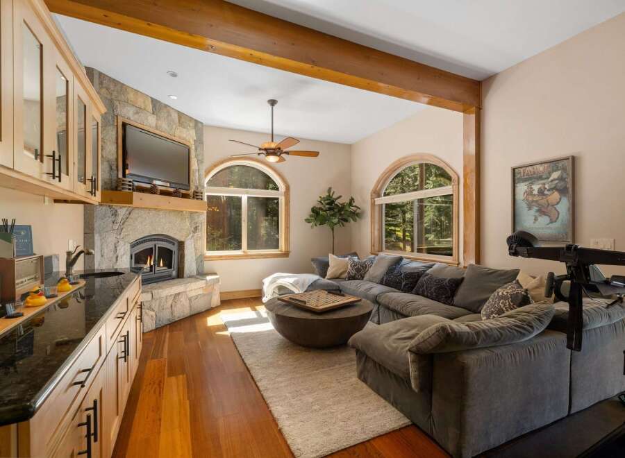 Experience cozy living with this stunning living room featuring a stone fireplace and a large sectional sofa perfect for relaxation.