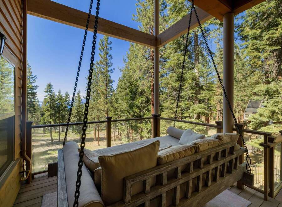 Relax and unwind on this charming porch swing, offering breathtaking views of the surrounding pine forest and distant lake.