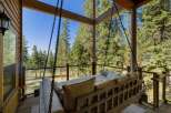 Relax and unwind on this charming porch swing, offering breathtaking views of the surrounding pine forest and distant lake.