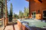 Experience ultimate relaxation in this stunning mountain retreat, featuring a luxurious hot tub on a spacious deck overlooking a serene forest landscape.